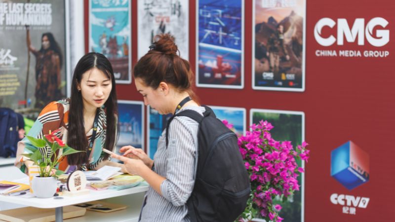 two women at Sunny Side of the Doc exchanging contact information