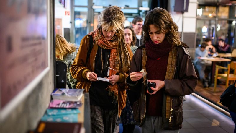 two women looking at the programme of the Verzio Film Festival