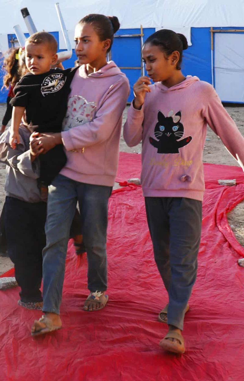 Three children walking the red carpet at the 2025 Gaza International Festival for Women's Cinema